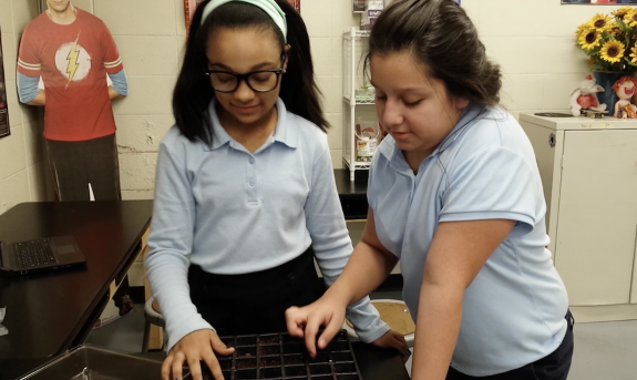 Two STEM Club students plant seedlings for a proposed hydroponic center in Joliet, Illinois.