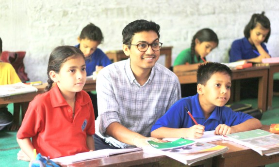 Project FUEL founder Deepak Ramola works with students in a classroom.